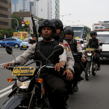 Indonesian policemen ride motorcycles as they patrol near the bomb blast site at Thamrin business district in Jakarta