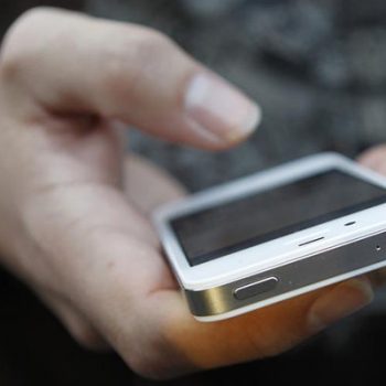 A customer uses his new iPhone 4S after making the purchase at Apple’s flagship retail store in San Francisco
